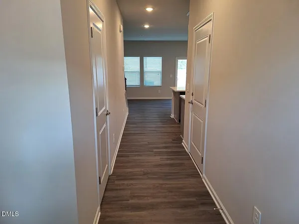 a view of a hallway with wooden floor and staircase