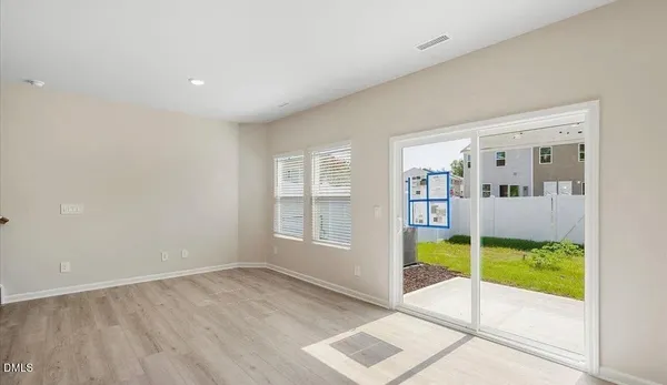 a view of an empty room with wooden floor and a tub