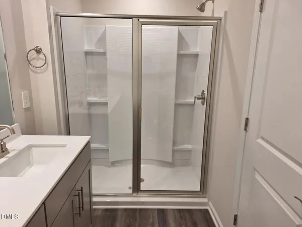 a bathroom with a shower sink and mirror