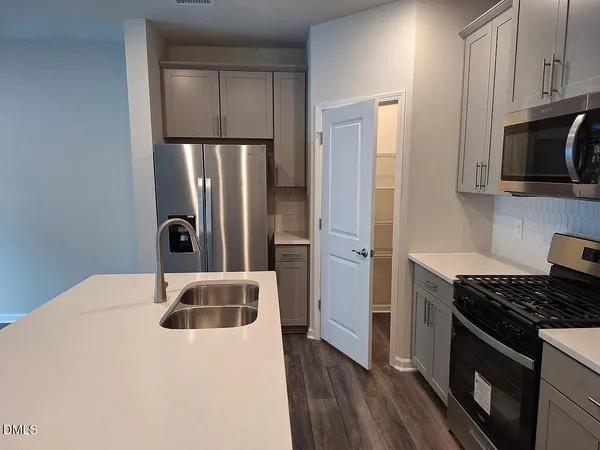 a kitchen with stainless steel appliances granite countertop a refrigerator and a stove top oven