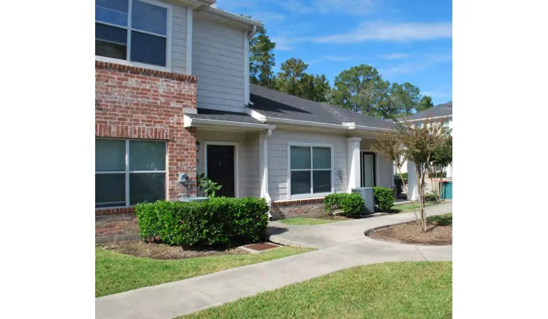 24011 Richards Road Spring, TX 77386 - Photo 3 of 14 a view of a house with brick walls plants and large tree