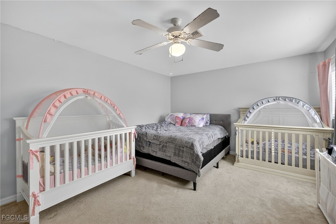 12899 Ivory Stone Loop Fort Myers, FL 33913 - Photo 19 of 40 a bedroom with a bed and a chandelier