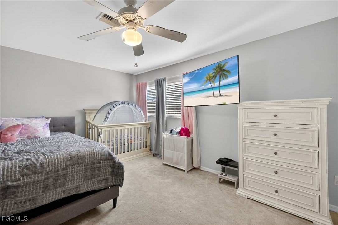 12899 Ivory Stone Loop Fort Myers, FL 33913 - Photo 20 of 40 a bedroom with a bed and a chandelier