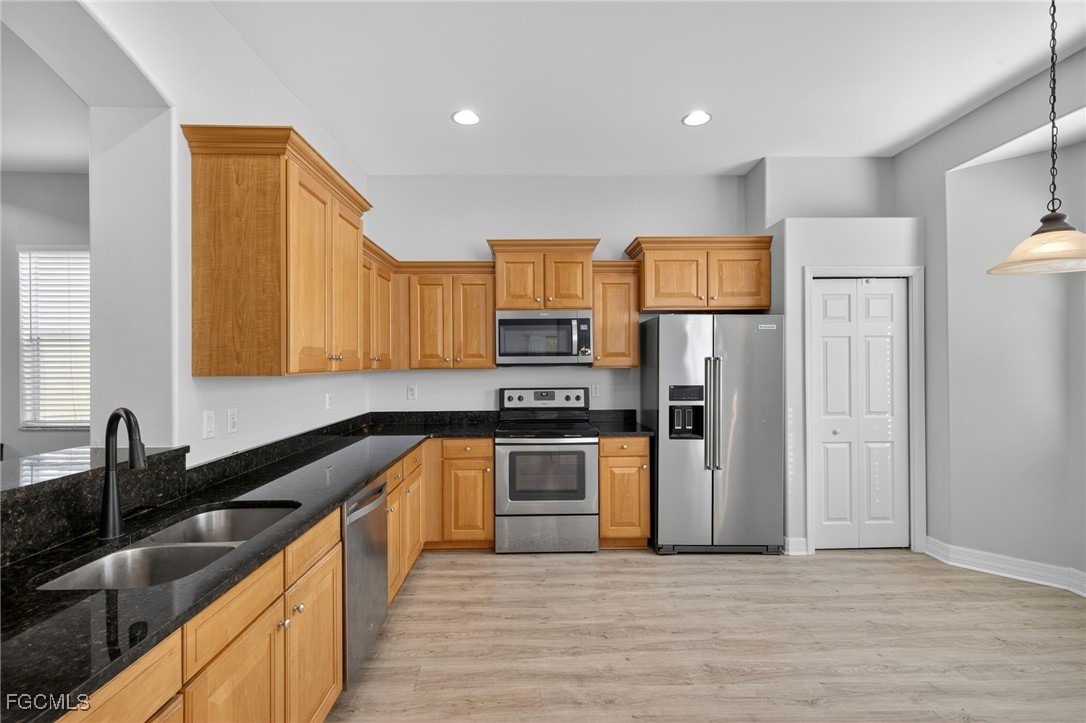 12899 Ivory Stone Loop Fort Myers, FL 33913 - Photo 7 of 40 a kitchen with stainless steel appliances granite countertop a sink stove and refrigerator
