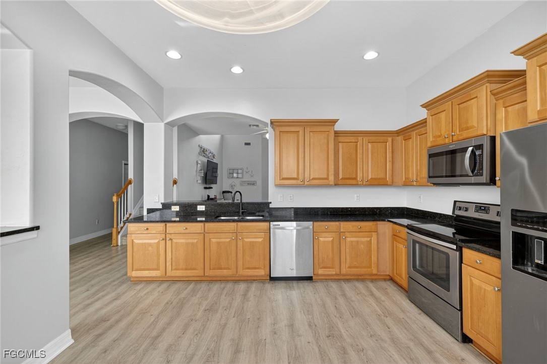 12899 Ivory Stone Loop Fort Myers, FL 33913 - Photo 8 of 40 a kitchen with stainless steel appliances granite countertop a stove a sink and a microwave