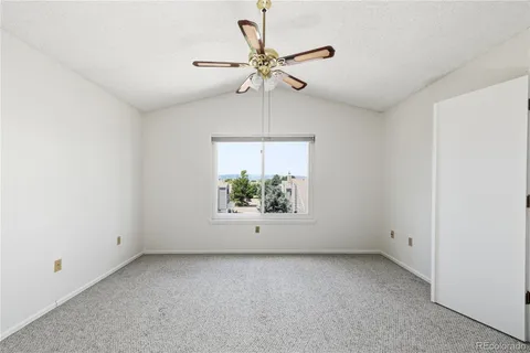 an empty room with a window and a ceiling fan
