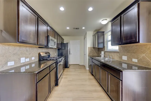 a kitchen with granite countertop cabinets sink and window