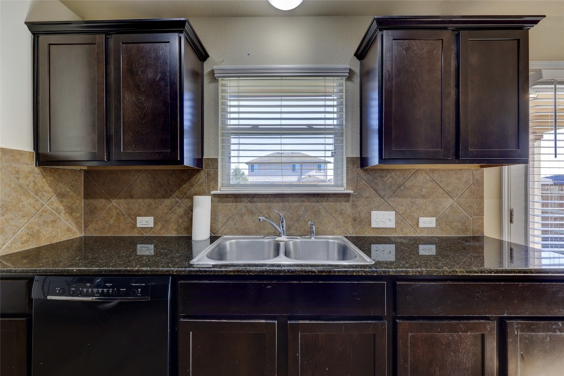 267 Voyager Cove Kyle, TX 78640 - Photo 15 of 40 a kitchen with granite countertop cabinets sink and window