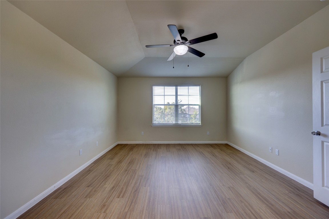 267 Voyager Cove Kyle, TX 78640 - Photo 18 of 40 an empty room with wooden floor fan and windows