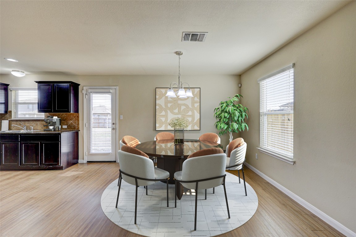 267 Voyager Cove Kyle, TX 78640 - Photo 2 of 40 a dining room with furniture a window and wooden floor