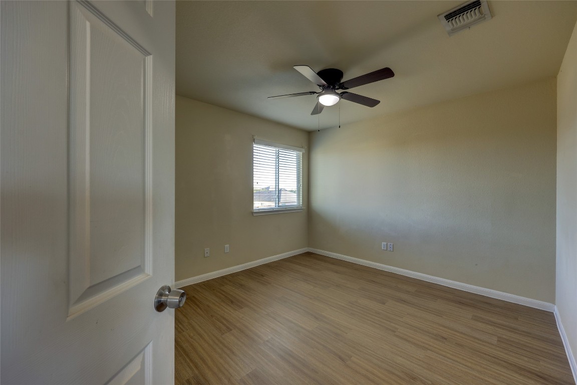 267 Voyager Cove Kyle, TX 78640 - Photo 26 of 40 a view of empty room with wooden floor and fan