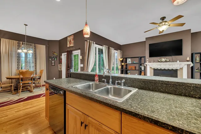 a kitchen with granite countertop a sink and a flat screen tv