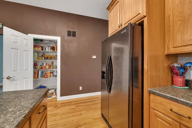 a kitchen with stainless steel appliances granite countertop a refrigerator and a sink