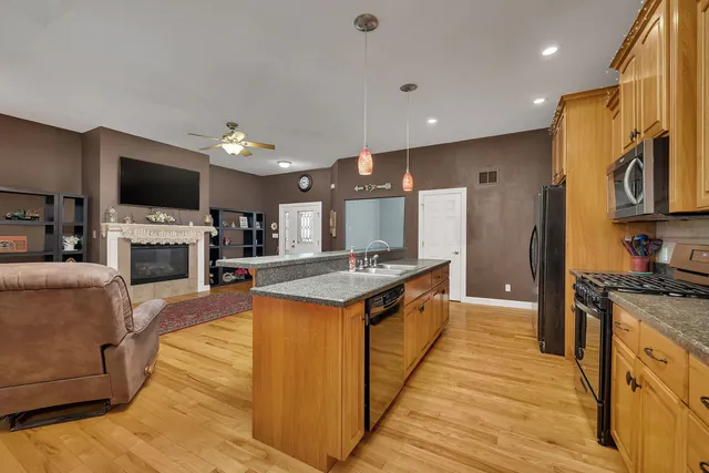 a large kitchen with stainless steel appliances granite countertop a stove oven and a refrigerator