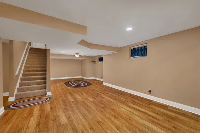 a view of an empty room with wooden floor and stairs