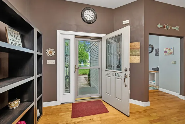 a view of a hallway with entryway wooden floor and front door