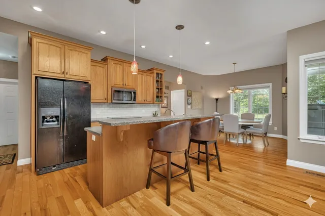 a kitchen with stainless steel appliances granite countertop a refrigerator and a stove top oven
