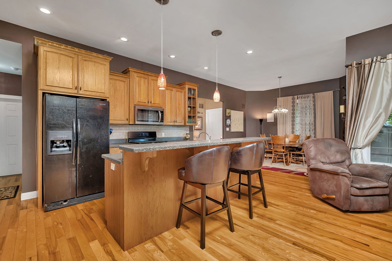 300 Village Lane Seneca, IL 61360 - Photo 10 of 42 a kitchen with stainless steel appliances granite countertop a refrigerator a stove and a wooden cabinets with wooden floor