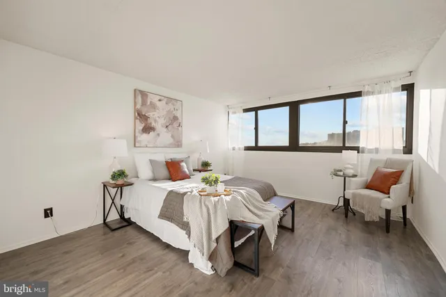 a bedroom with a bed and a large window