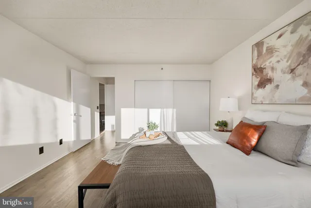 a bedroom with a large bed and a painting on the wall