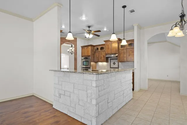 a view of dining table chairs and chandelier