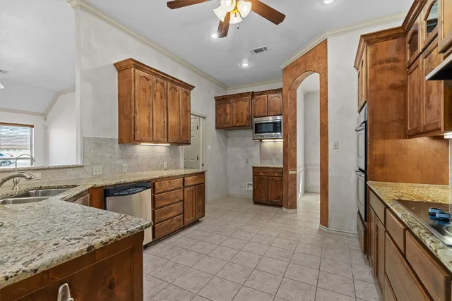 a kitchen with stainless steel appliances granite countertop a sink stove and refrigerator