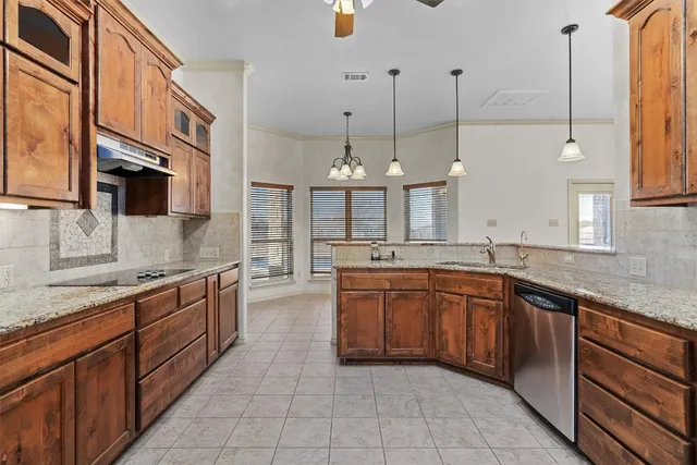 a large kitchen with stainless steel appliances granite countertop a sink a stove a counter space and cabinets