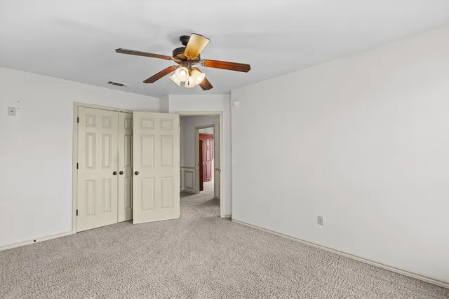 a view of room with a ceiling fan and window