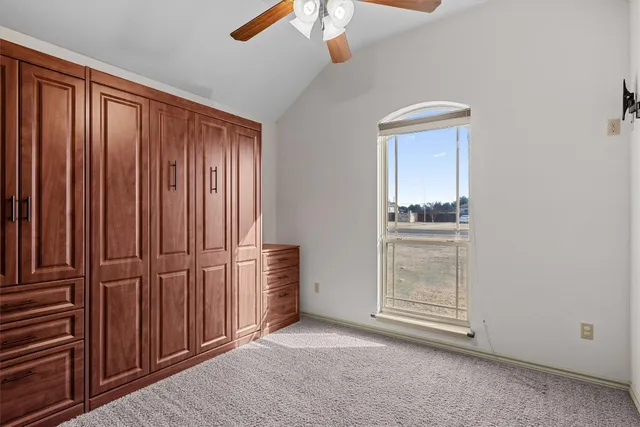 an empty room with windows cabinet and hallway