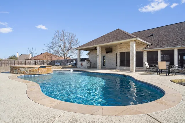 a view of a house with swimming pool and sitting area