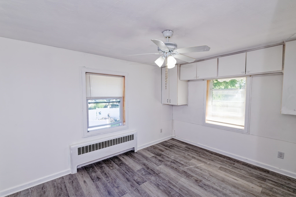 1 Rockland Rd Court Auburn, MA 01501 - Photo 18 of 38 an empty room with wooden floor chandelier fan and windows