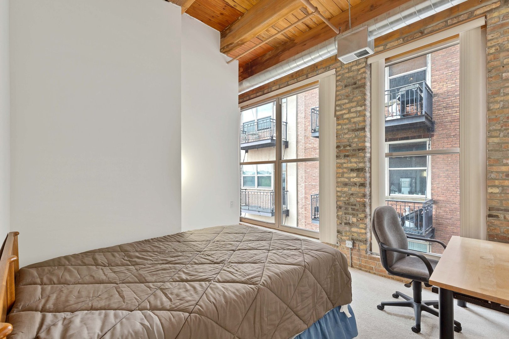 550 West Harrison Street, Unit 453 Chicago, IL 60607 - Photo 9 of 17 a bedroom with a bed and a window