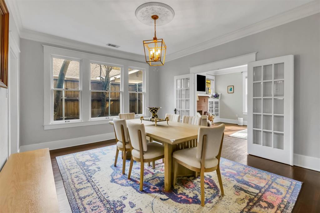 307 North Edgefield Avenue Dallas, TX 75208 - Photo 9 of 28 a dining room with wooden floor a chandelier a wooden table and chairs