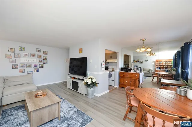 a living room with furniture a flat screen tv and kitchen view