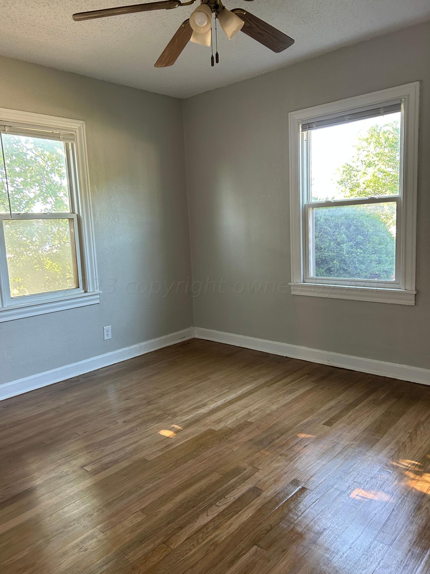 1408 Southwest 12th Avenue Amarillo, TX 79102 - Photo 13 of 25 an empty room with wooden floor and windows