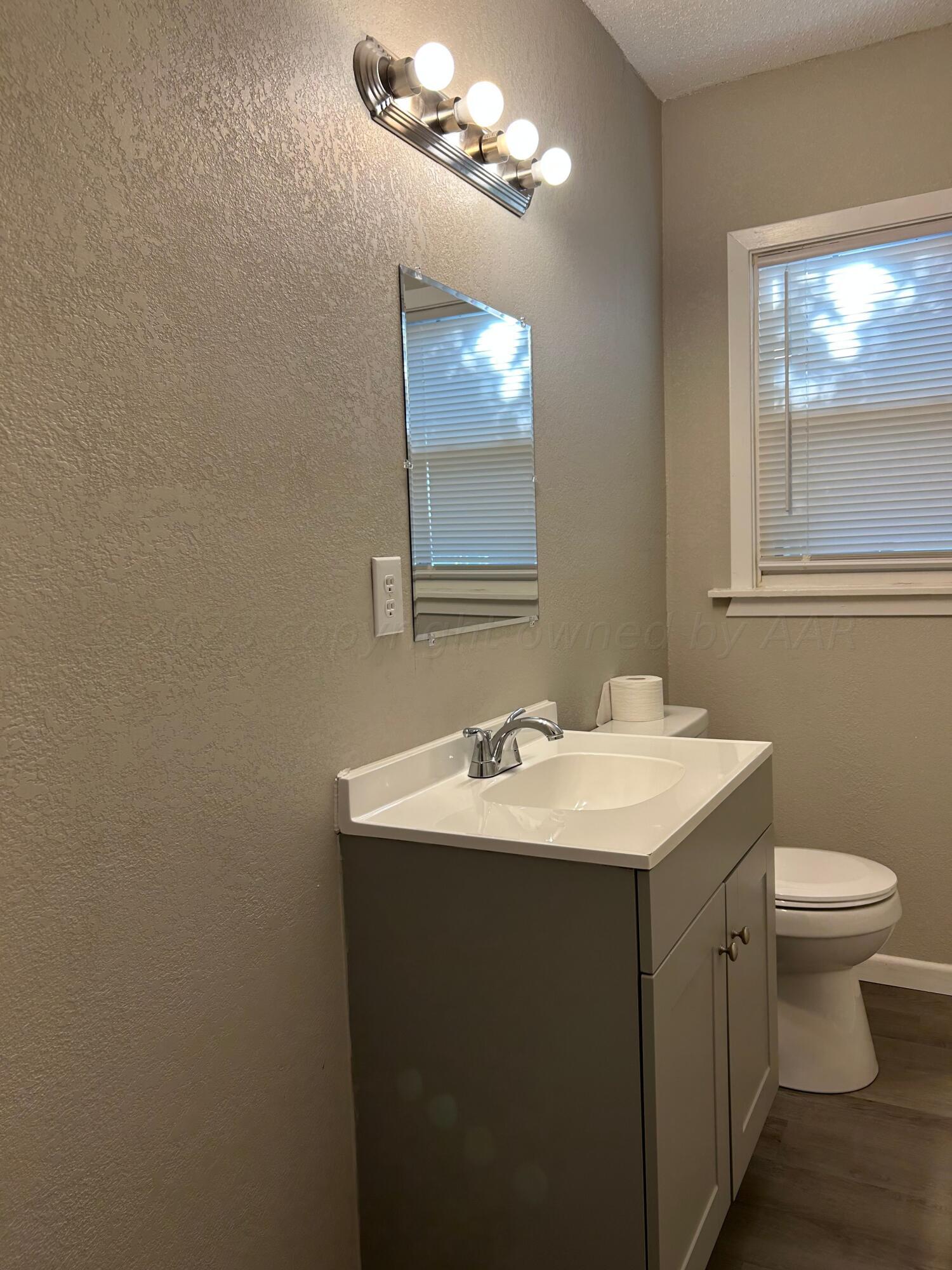 1408 Southwest 12th Avenue Amarillo, TX 79102 - Photo 14 of 25 a bathroom with a toilet a sink and mirror