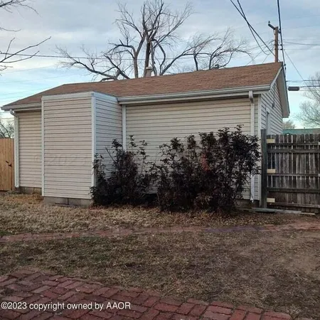 a view of backyard with wooden fence and a large tree
