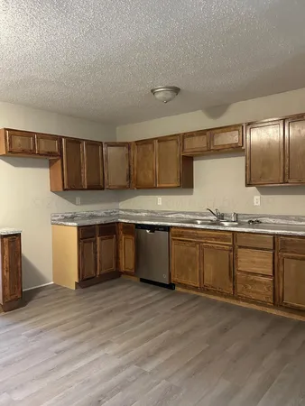 a kitchen with stainless steel appliances a sink a stove top oven a counter space and cabinets