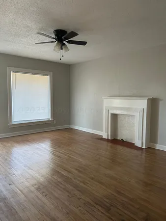 a view of a room with wooden floor and a ceiling fan