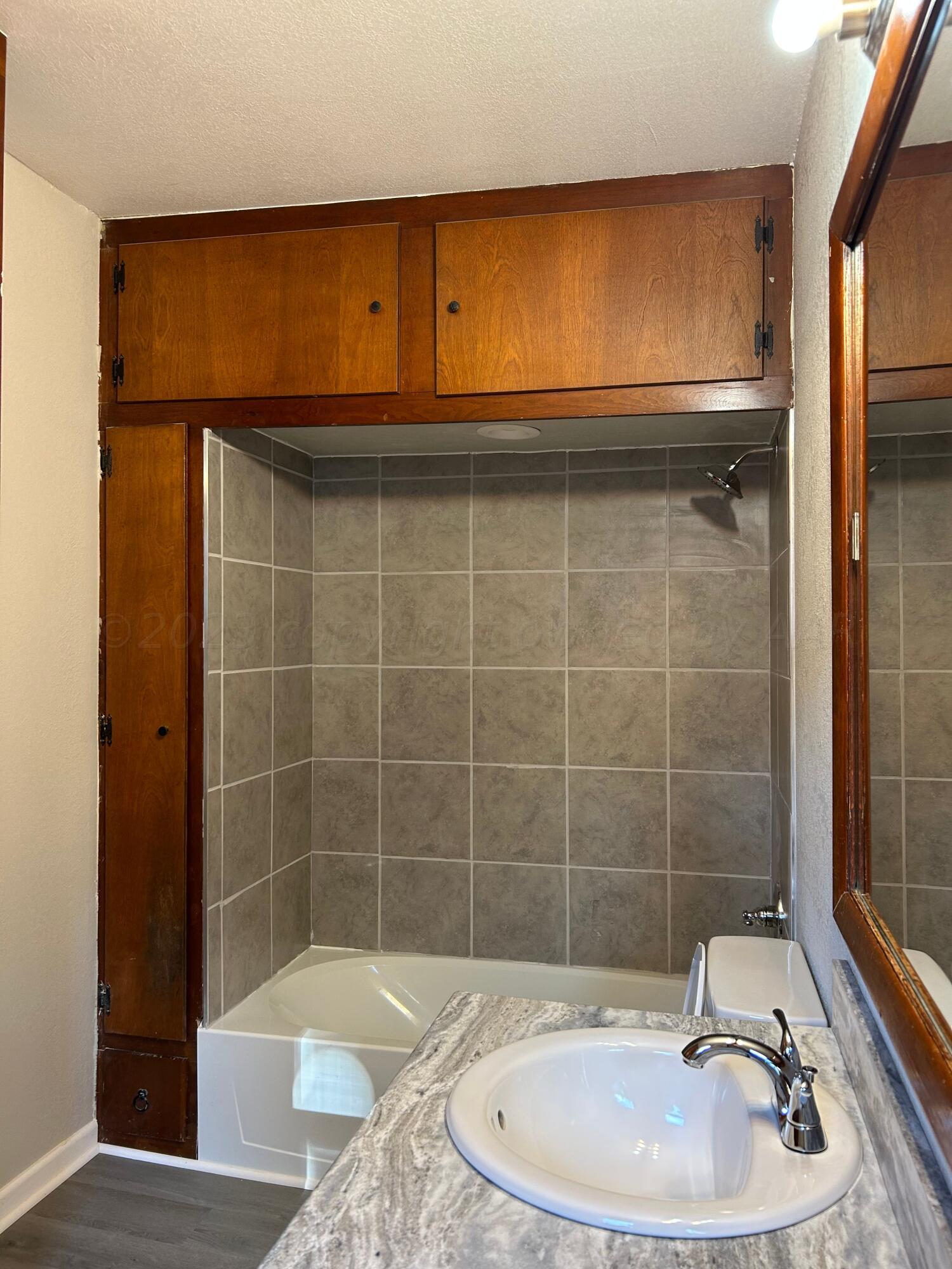 1408 Southwest 12th Avenue Amarillo, TX 79102 - Photo 9 of 25 a bathroom with a sink a toilet and shower