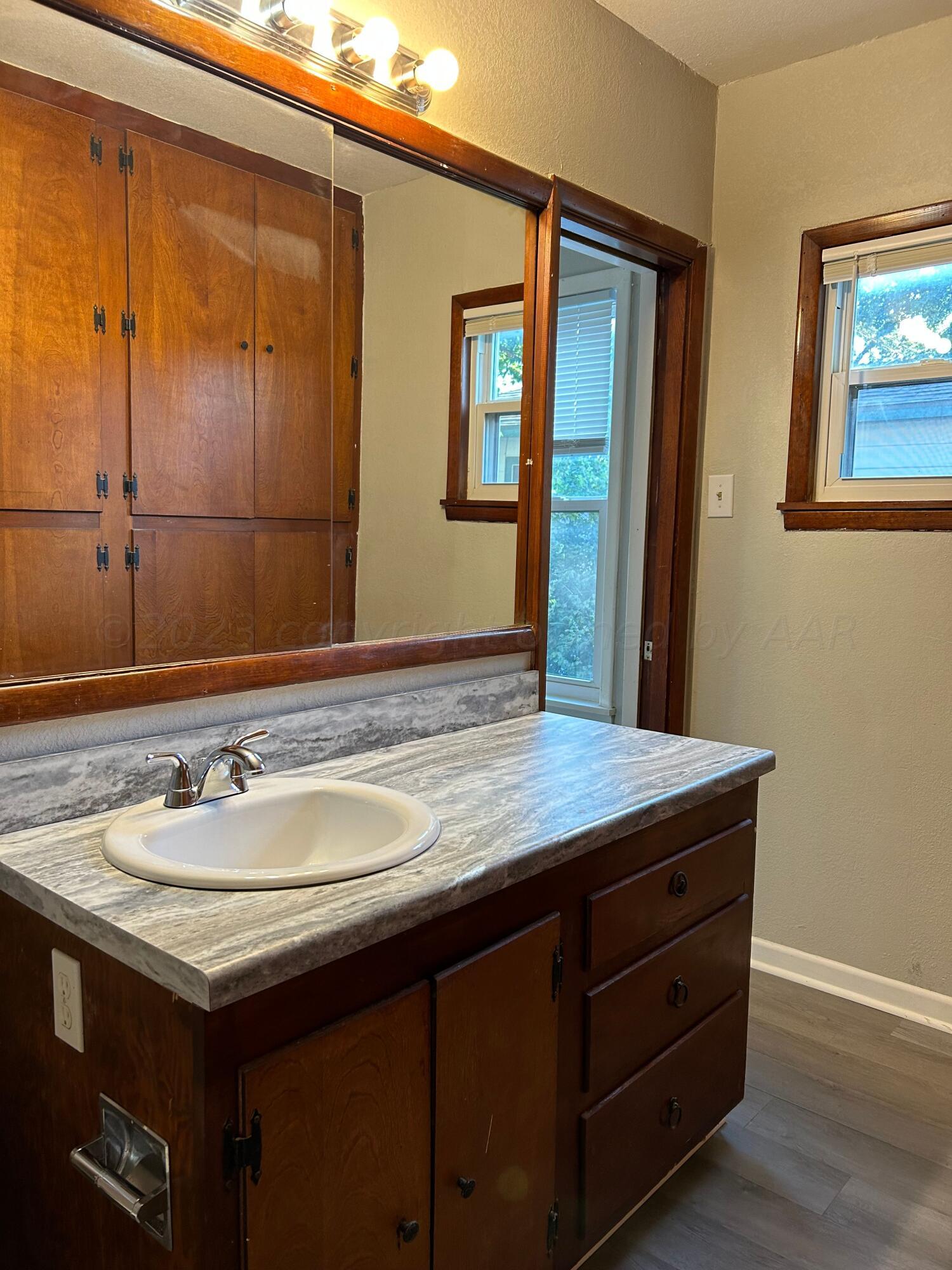 1408 Southwest 12th Avenue Amarillo, TX 79102 - Photo 10 of 25 a bathroom with a granite countertop sink and a mirror