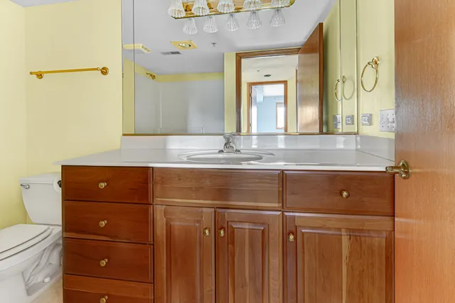 a bathroom with a sink a toilet and a mirror