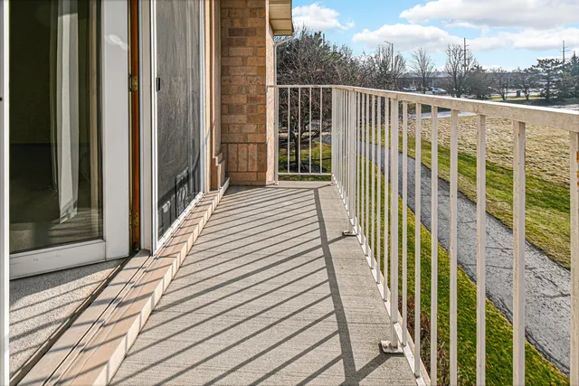 a view of a balcony with wooden floor and fence