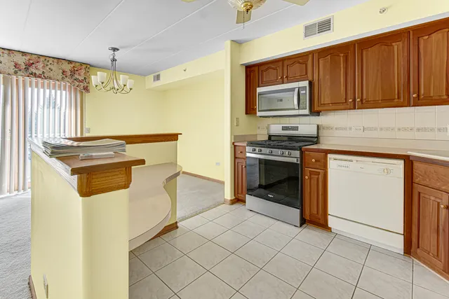 a kitchen with granite countertop cabinets stainless steel appliances and a counter space