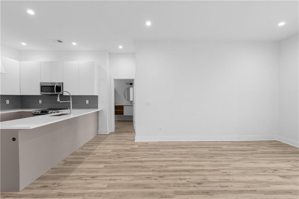 1155 Custer Avenue Southeast, Unit 301 Atlanta, GA 30316 - Photo 14 of 22 a large kitchen with stainless steel appliances a large counter top and a stove