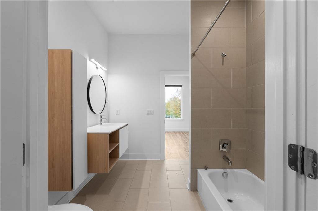 1155 Custer Avenue Southeast, Unit 301 Atlanta, GA 30316 - Photo 20 of 22 a bathroom with a sink a mirror and a bathtub