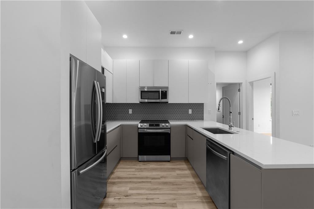1155 Custer Avenue Southeast, Unit 301 Atlanta, GA 30316 - Photo 5 of 22 a kitchen with stainless steel appliances granite countertop a sink stove and refrigerator