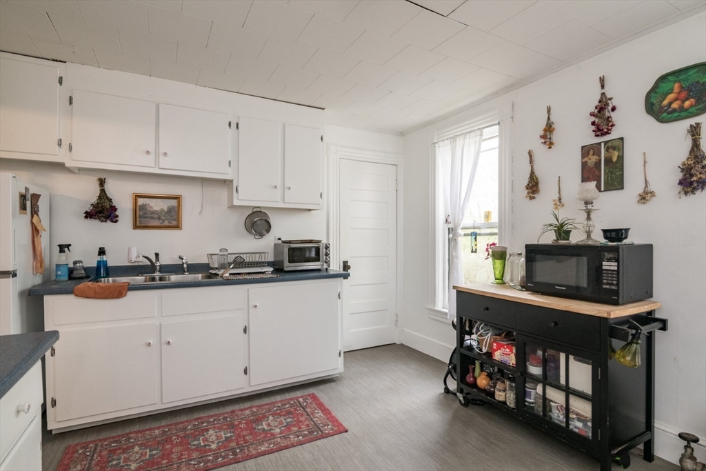 25 Morgan Street Holyoke, MA 01040 - Photo 13 of 41 a kitchen with white cabinets and sink