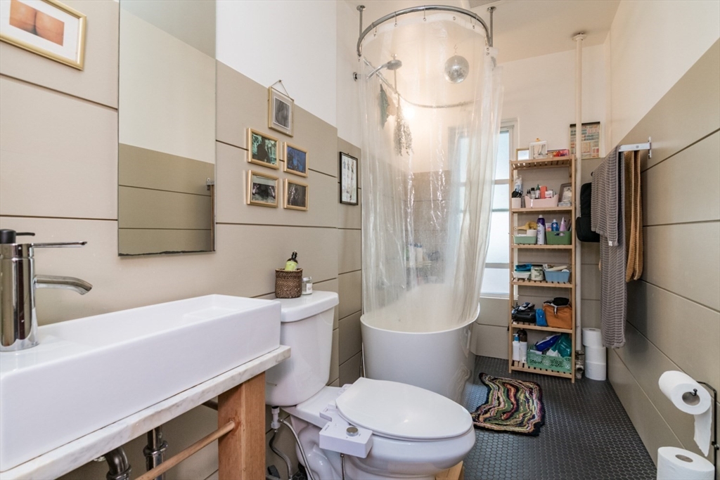 25 Morgan Street Holyoke, MA 01040 - Photo 31 of 41 a bathroom with a sink a toilet a shower curtain and a mirror