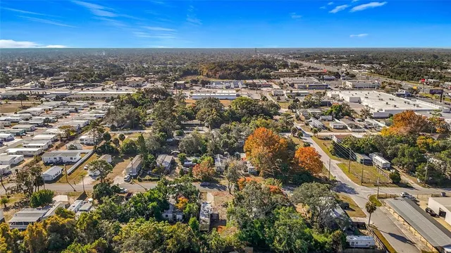 an aerial view of residential houses with outdoor space and trees